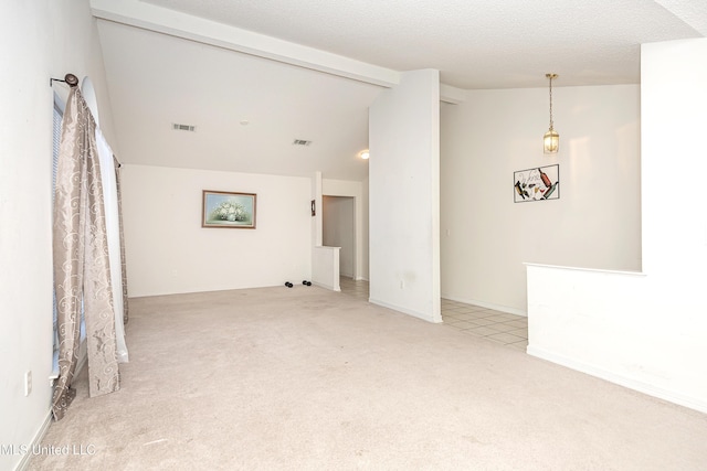 carpeted spare room featuring lofted ceiling with beams and a textured ceiling