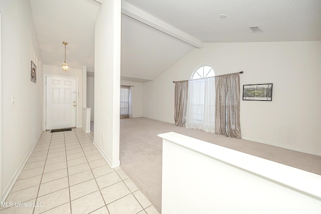 hallway featuring lofted ceiling with beams, light colored carpet, and a textured ceiling