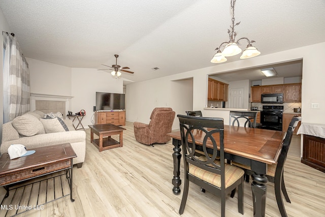 dining room featuring ceiling fan, light hardwood / wood-style floors, and a textured ceiling