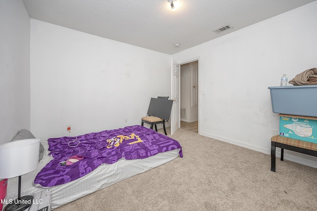 bedroom featuring light carpet and a textured ceiling