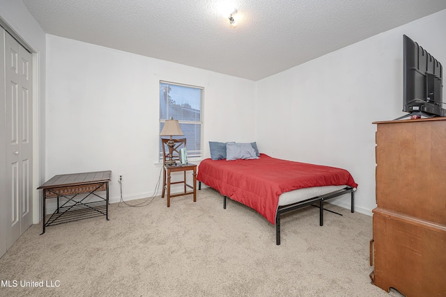 carpeted bedroom featuring a closet and a textured ceiling