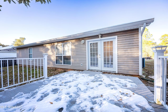 snow covered deck featuring french doors