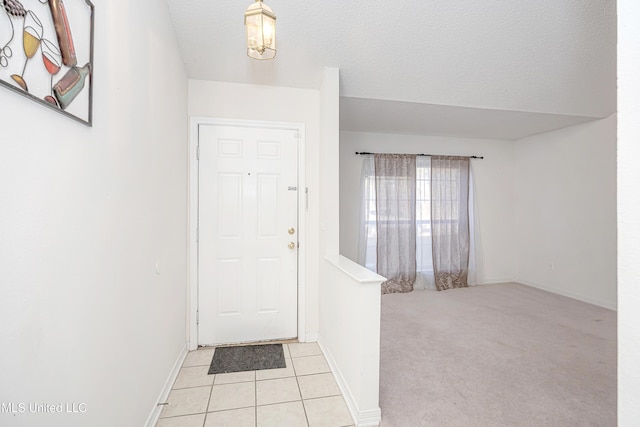 foyer entrance featuring light tile patterned floors and a textured ceiling