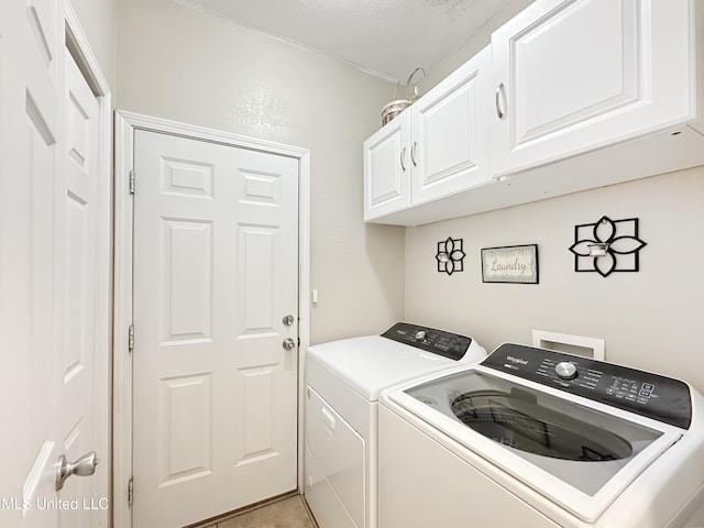 clothes washing area featuring separate washer and dryer and cabinet space