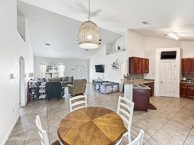 dining room with light tile patterned floors, high vaulted ceiling, visible vents, and a chandelier