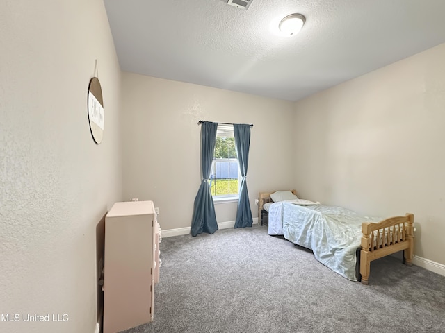 bedroom with carpet floors, baseboards, and a textured ceiling