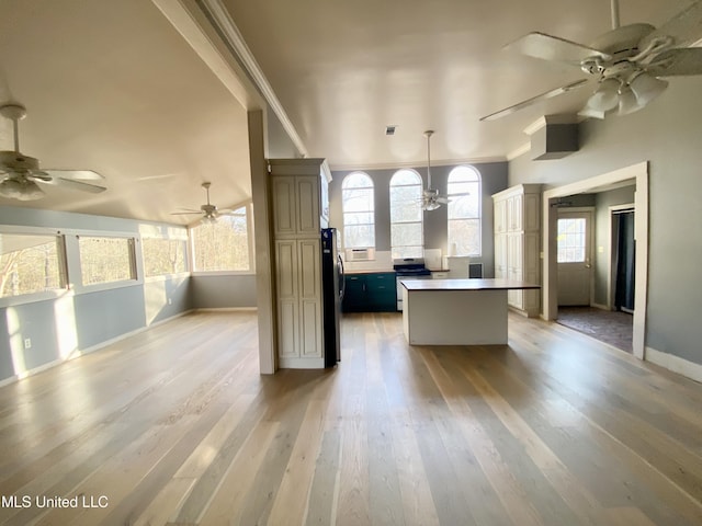 kitchen featuring crown molding, light hardwood / wood-style flooring, stainless steel appliances, and a center island