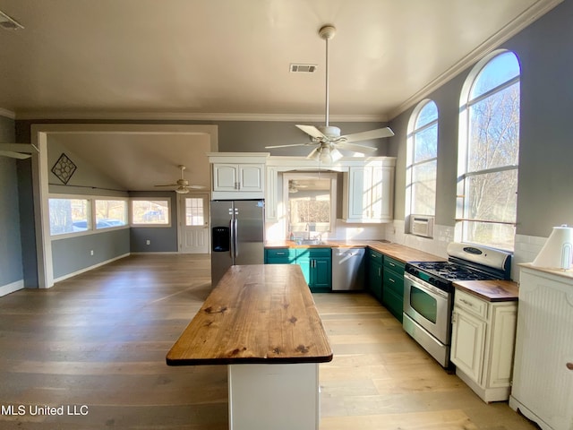 kitchen featuring blue cabinets, white cabinetry, wooden counters, a center island, and stainless steel appliances