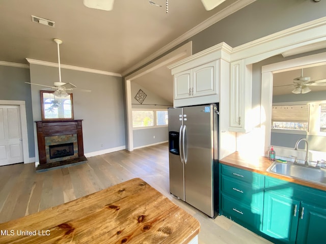 kitchen with sink, crown molding, ceiling fan, white cabinetry, and stainless steel fridge with ice dispenser
