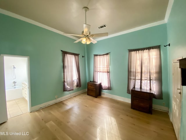 unfurnished bedroom featuring ceiling fan, ensuite bath, ornamental molding, and light wood-type flooring