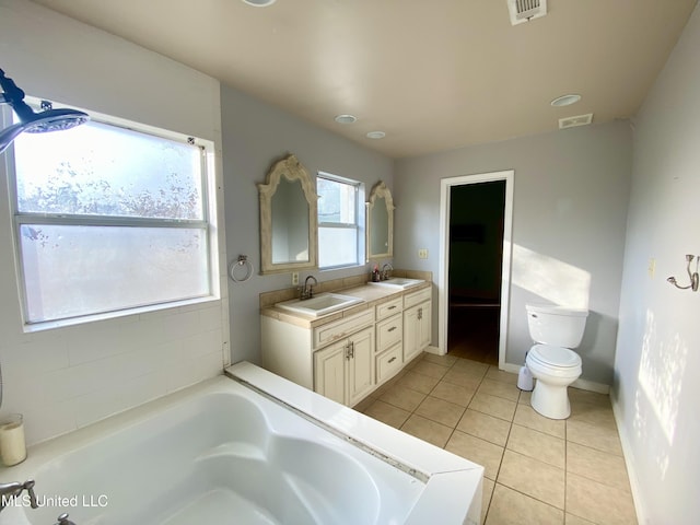 bathroom with vanity, a bathing tub, tile patterned floors, and toilet