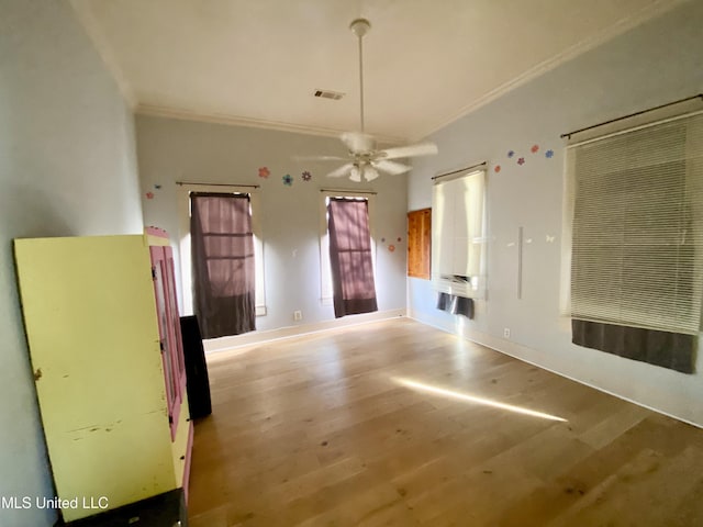 interior space with ornamental molding, ceiling fan, and light wood-type flooring