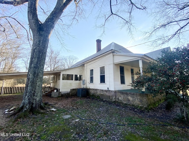 view of property exterior with central air condition unit and covered porch