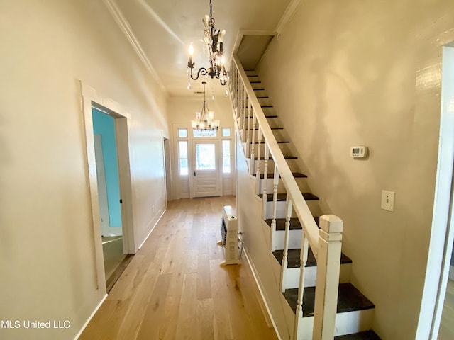 interior space with ornamental molding, hardwood / wood-style floors, and a chandelier