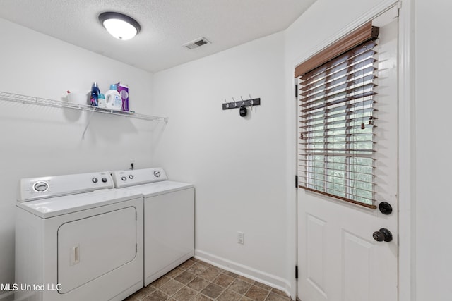 laundry area featuring washer and dryer, baseboards, and a textured ceiling