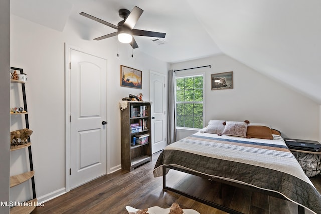 bedroom with dark wood-style flooring, vaulted ceiling, a ceiling fan, and baseboards