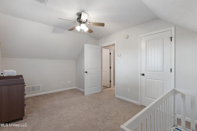 additional living space featuring lofted ceiling, a ceiling fan, carpet floors, and baseboards