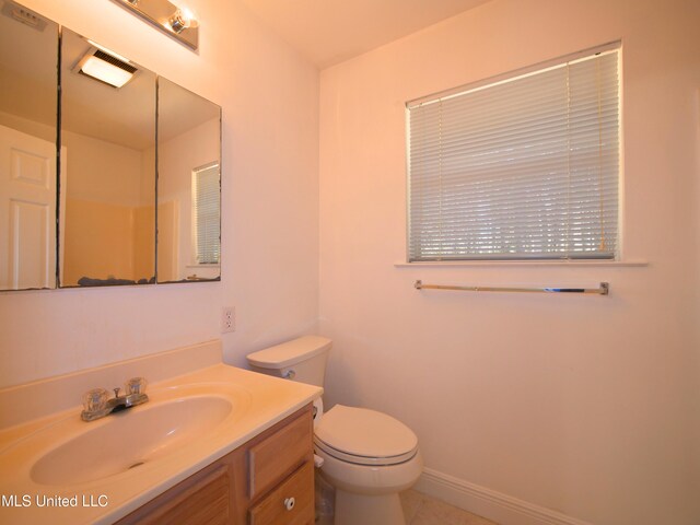 bathroom featuring visible vents, toilet, vanity, and baseboards