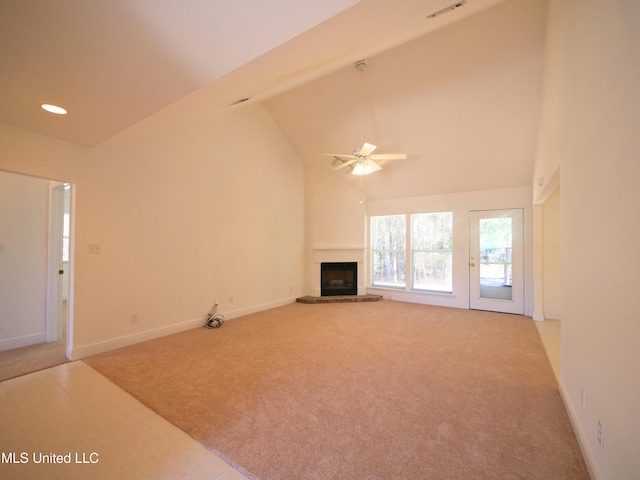 unfurnished living room featuring high vaulted ceiling, light colored carpet, and a fireplace with raised hearth