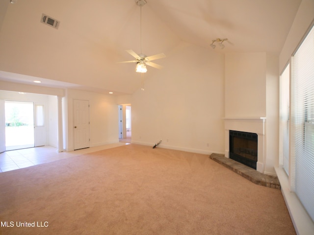 unfurnished living room with visible vents, a ceiling fan, light colored carpet, a brick fireplace, and high vaulted ceiling