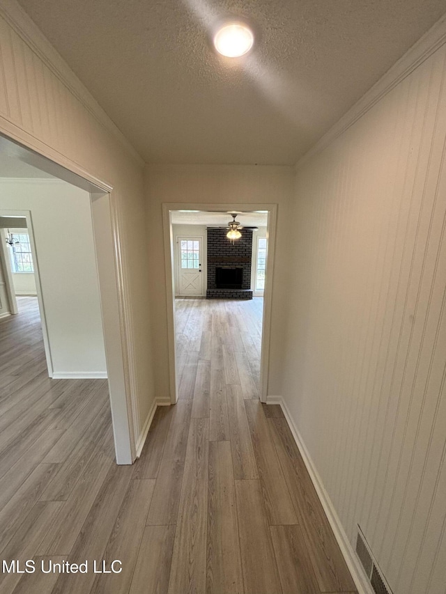 747 Cumberland Cv, Southaven, MS 38671 - hall with baseboards, a textured ceiling, wood finished floors, and crown molding