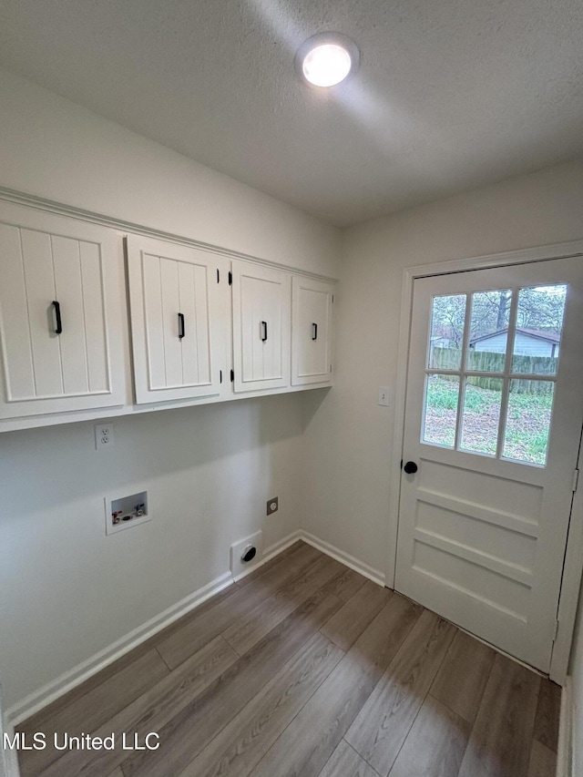 747 Cumberland Cv, Southaven, MS 38671 - laundry room featuring dark wood-style flooring, hookup for a washing machine, baseboards, cabinet space, and electric dryer hookup