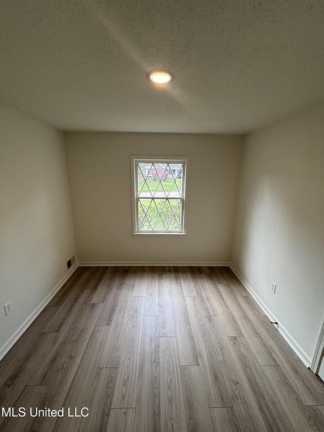 747 Cumberland Cv, Southaven, MS 38671 - unfurnished room with baseboards, a textured ceiling, and wood finished floors