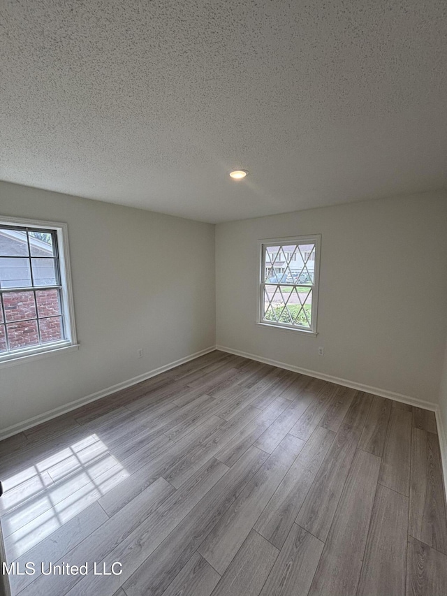 747 Cumberland Cv, Southaven, MS 38671 - empty room featuring baseboards, wood finished floors, and a textured ceiling