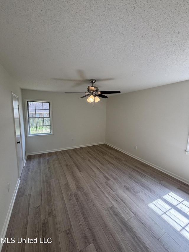 747 Cumberland Cv, Southaven, MS 38671 - empty room with dark wood-type flooring, a textured ceiling, baseboards, and ceiling fan