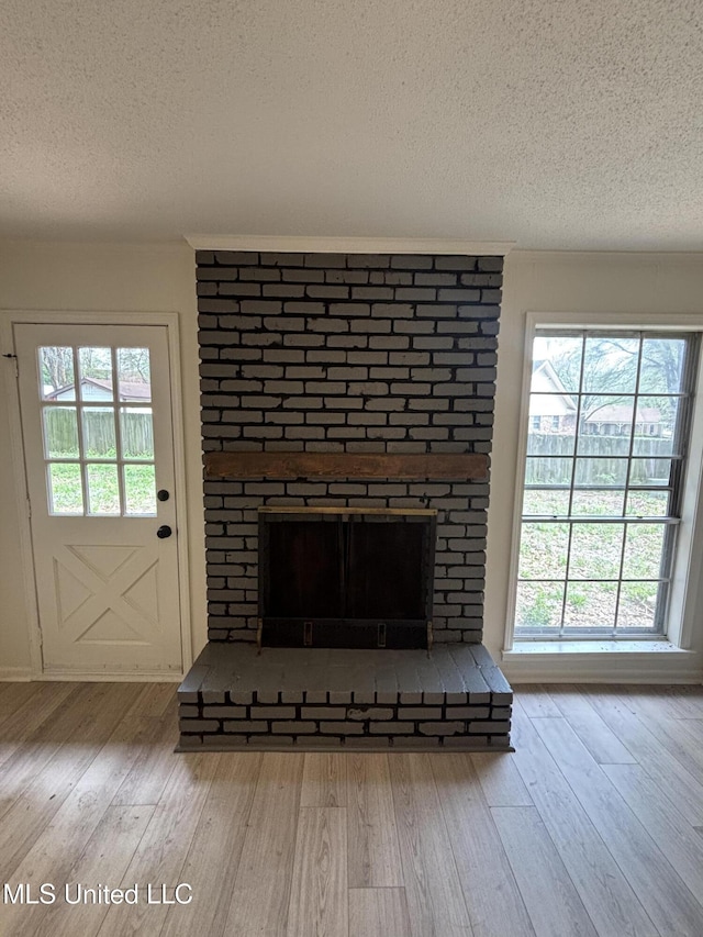 747 Cumberland Cv, Southaven, MS 38671 - room details featuring a brick fireplace, a textured ceiling, and wood finished floors