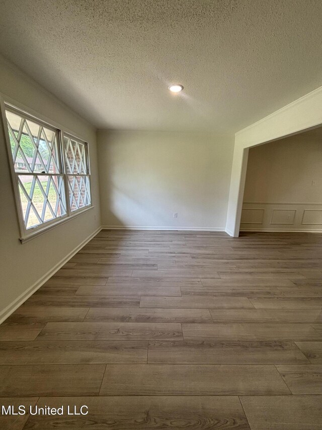747 Cumberland Cv, Southaven, MS 38671 - unfurnished room featuring a textured ceiling, wood finished floors, and a decorative wall