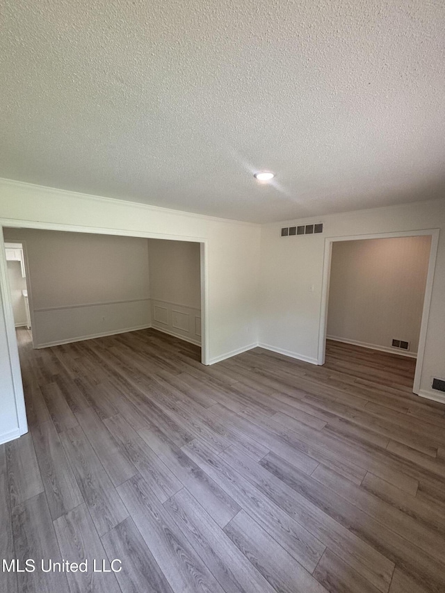 747 Cumberland Cv, Southaven, MS 38671 - empty room with wood finished floors, a textured ceiling, and visible vents