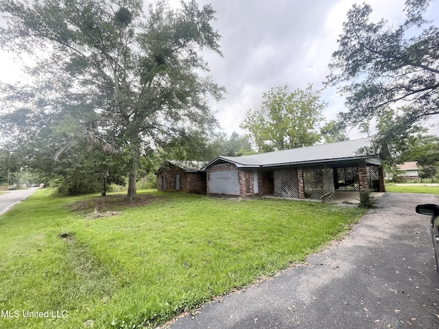 14920 Garrett St, Ocean Springs, MS 39565 - view of front facade with asphalt driveway, a front lawn, an attached carport, and metal roof