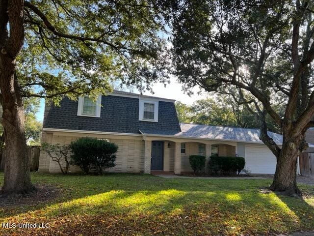 view of front of home with a front yard and a garage