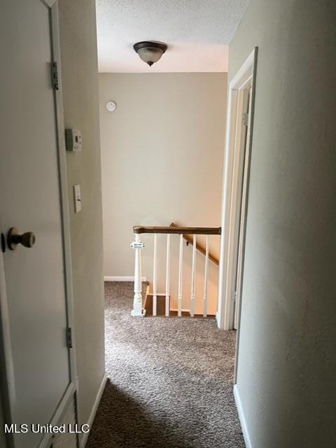 hallway featuring carpet and a textured ceiling