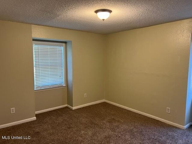 carpeted empty room with a textured ceiling