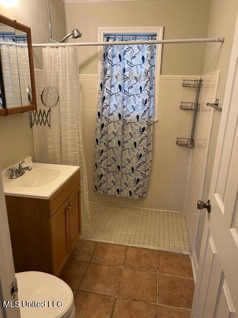 bathroom featuring vanity, a shower with curtain, toilet, and tile patterned floors