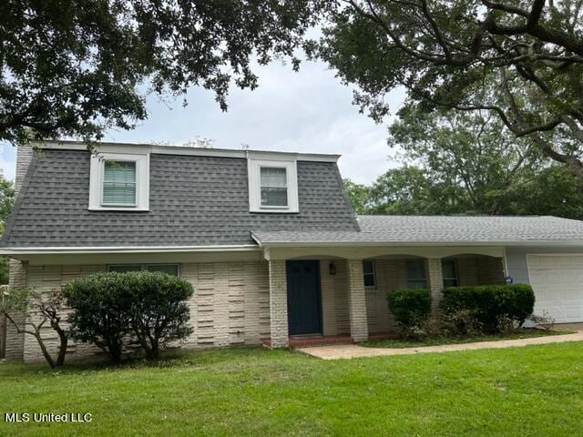 view of front of home with a front lawn and a garage