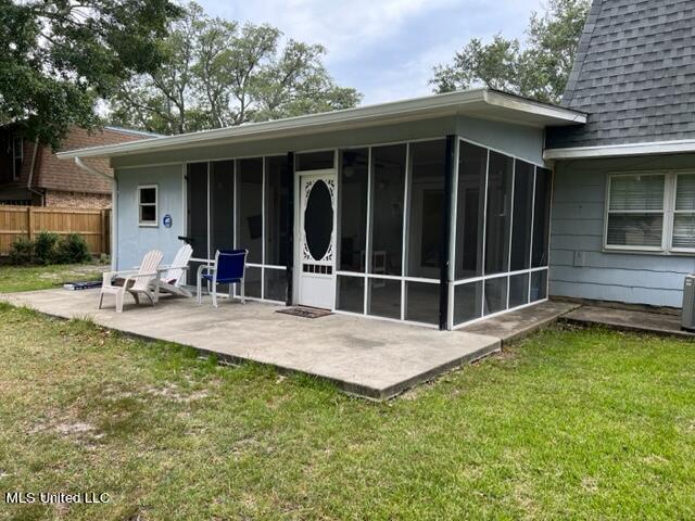 back of house featuring a yard, a sunroom, and a patio area