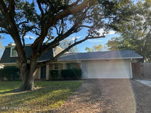 single story home featuring a garage and a front lawn