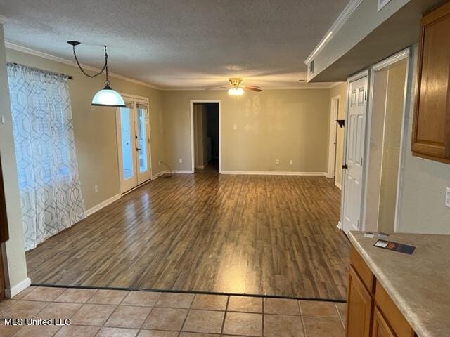 interior space featuring light hardwood / wood-style floors, crown molding, a textured ceiling, and ceiling fan