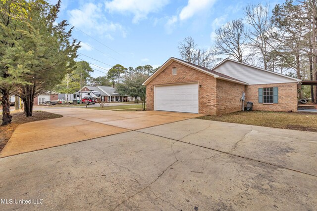 view of front of home featuring an attached garage, concrete driveway, and brick siding