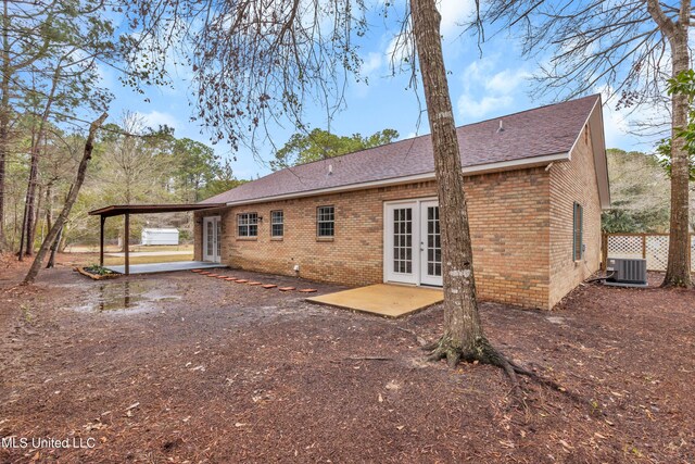 rear view of house with french doors, an attached carport, a patio area, and brick siding