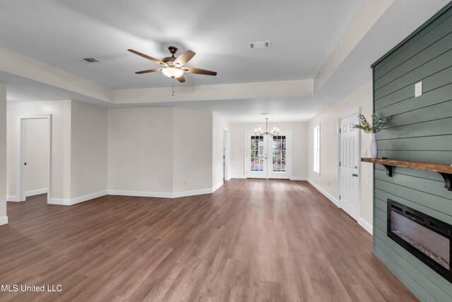 unfurnished living room with a large fireplace, visible vents, and wood finished floors