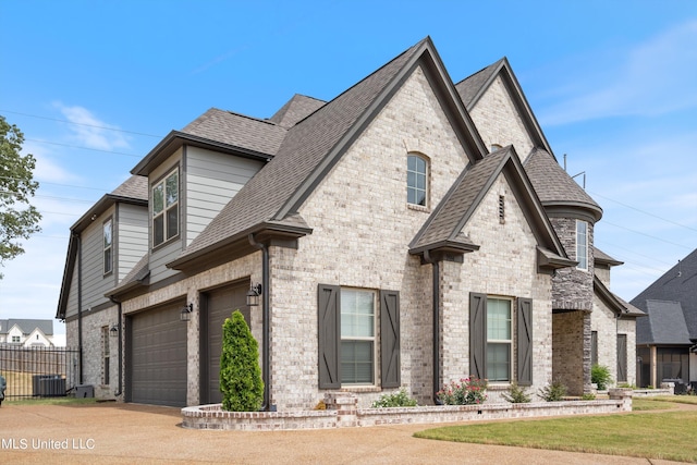 french country inspired facade with a garage and central AC