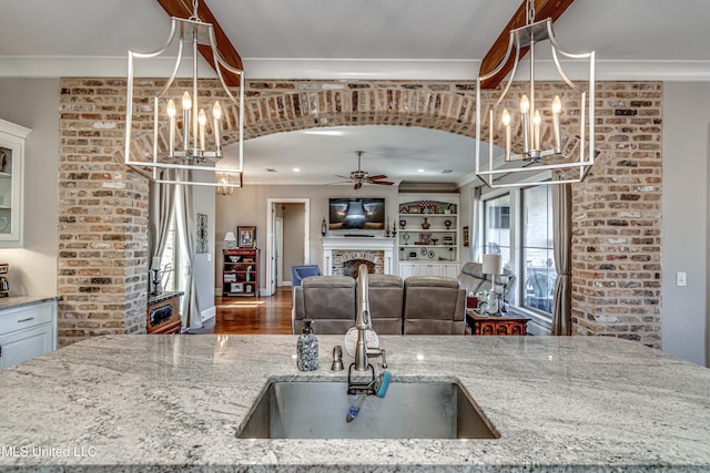 kitchen featuring ornamental molding, hanging light fixtures, and light stone countertops