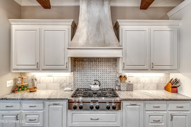 kitchen featuring white cabinetry, stainless steel gas cooktop, custom exhaust hood, and backsplash