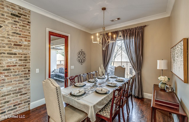 dining area with a chandelier, ornamental molding, and dark hardwood / wood-style floors