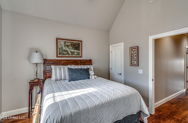 bedroom featuring dark hardwood / wood-style flooring and high vaulted ceiling