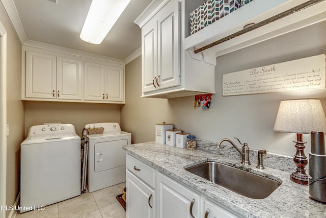 laundry area featuring independent washer and dryer, light tile patterned flooring, sink, ornamental molding, and cabinets